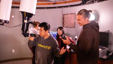 Astrophysics Minor student looking through telescope